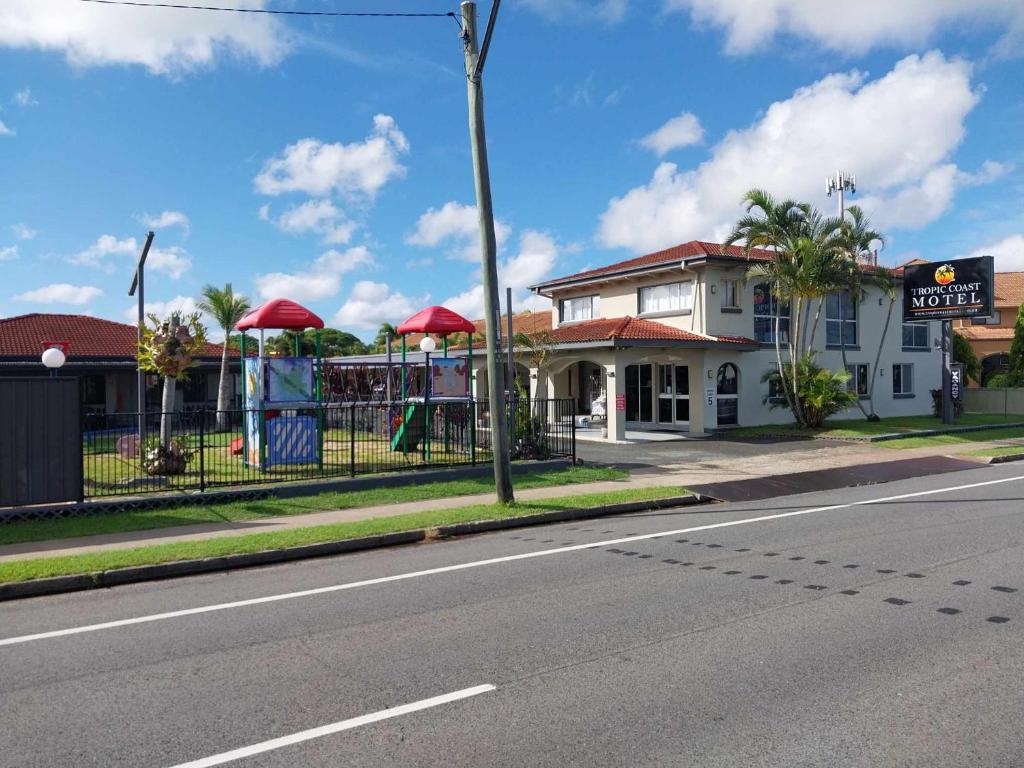 a building with red umbrellas on the side of a street at Tropic Coast Motel in Mackay