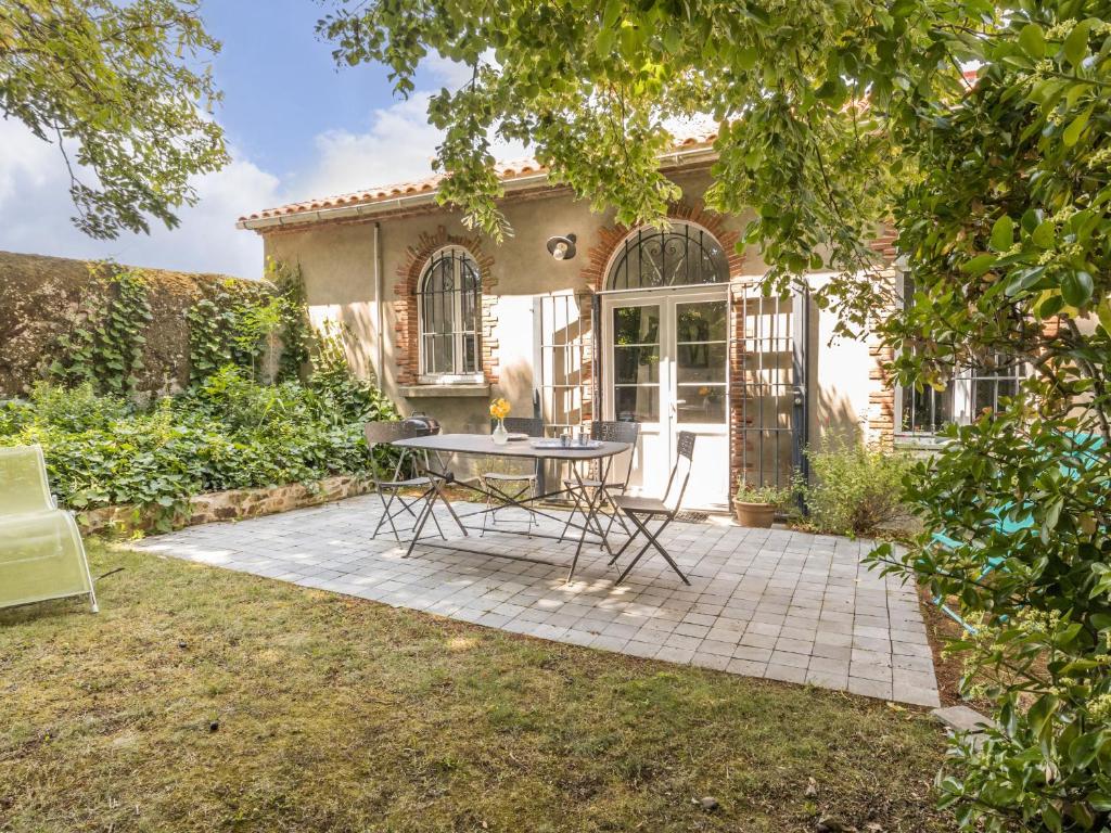 a patio with a table in front of a house at Gîte de charme entre Nantes et Côte de Jade - Jardin privé, équipement bébé, wifi, animaux acceptés - FR-1-306-852 in Vue