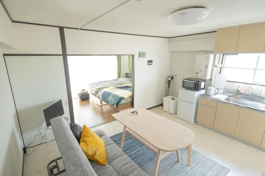 - un salon avec un canapé, une table et un lit dans l'établissement NOBEYAMA WIND, à Tokyo