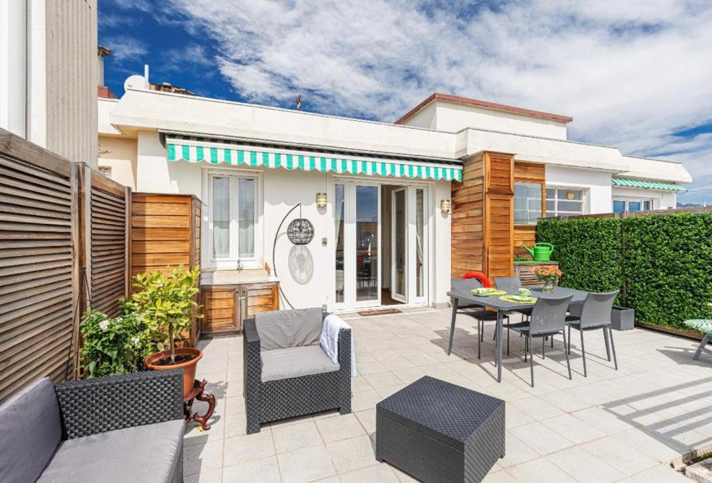 une terrasse avec une table et des chaises ainsi qu'une maison dans l'établissement Deux pièces terrasse sous les étoiles, à Nice
