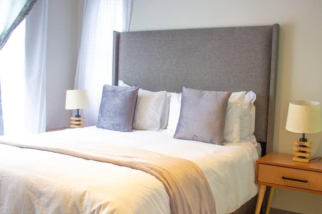 a bedroom with a large bed with white sheets and pillows at 11 Elizabeth Place - Luxury Apartments, Free Wi-Fi in Midrand