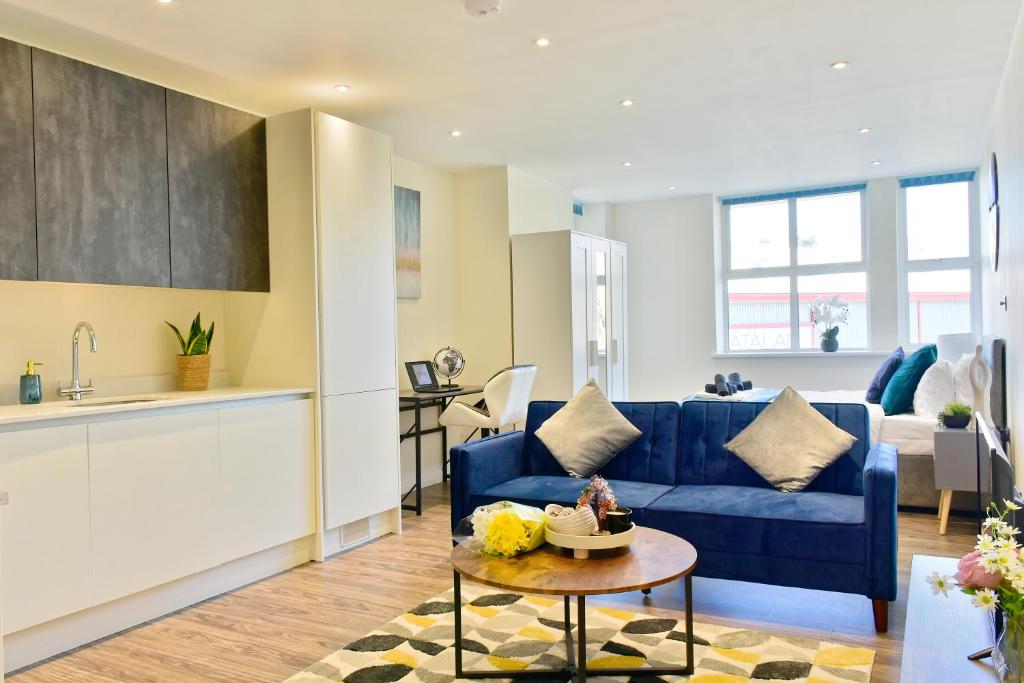 sala de estar con sofá azul y mesa en Stunning apartment near citycentre & Oracle, en Reading