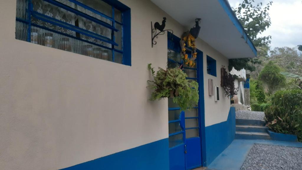 un bâtiment bleu et blanc avec une porte bleue dans l'établissement Kitnet em meio à mata Atlântica, à Juquitiba