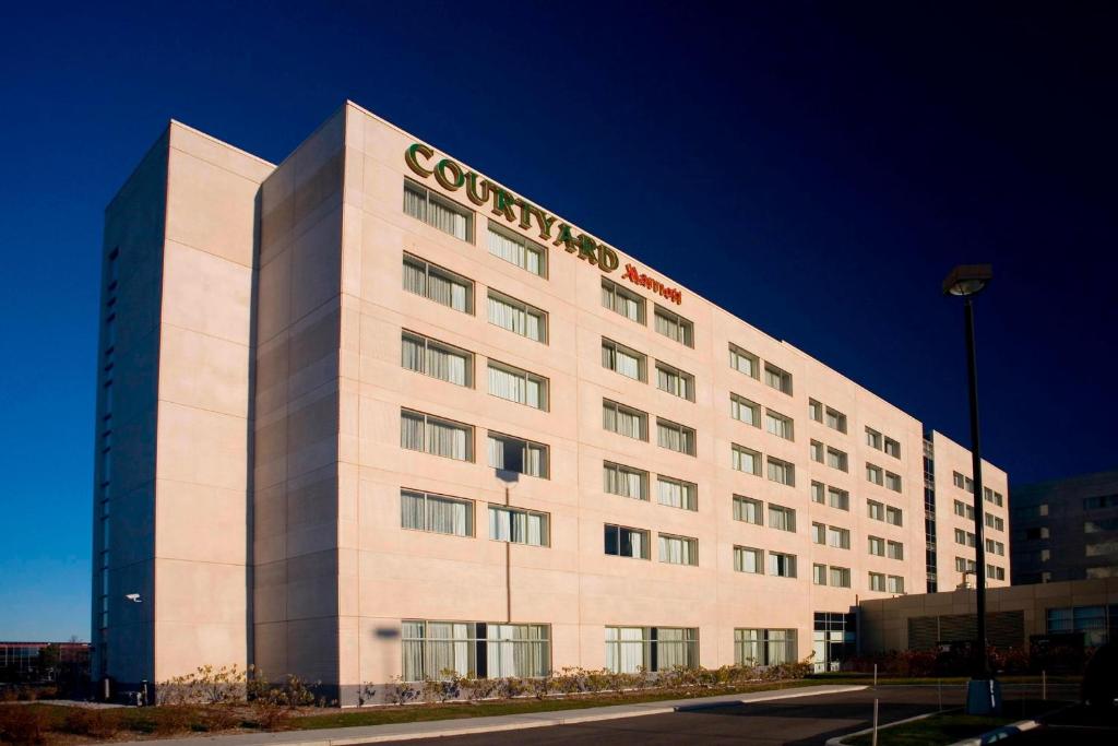 un edificio con un cartel de la compañía en el costado. en Courtyard by Marriott Montreal Airport en Dorval