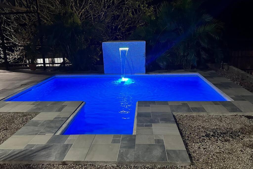 una piscina azul con una fuente de agua en Villa Bienvenida Costa Rica en Santa Cruz