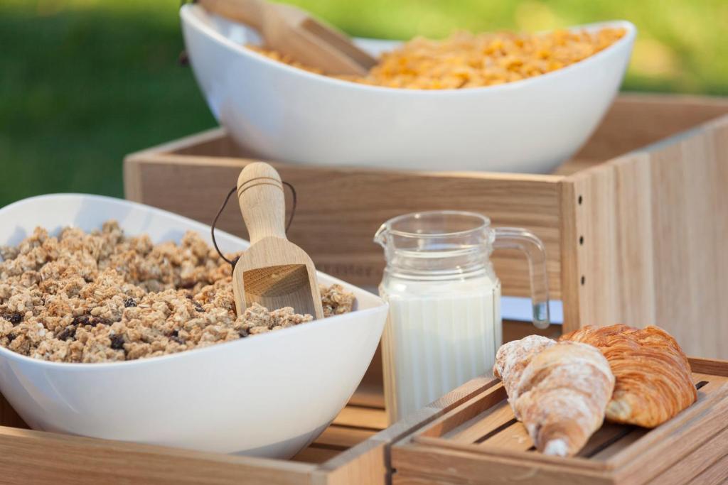 a wooden tray with bowls of food and a container of milk at Holiday Inn Express Porto - Boavista, an IHG Hotel in Porto