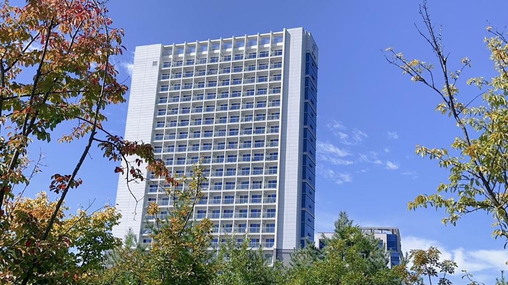 a tall white building with a lot of windows at Yongjiong Shine Hotel in Incheon