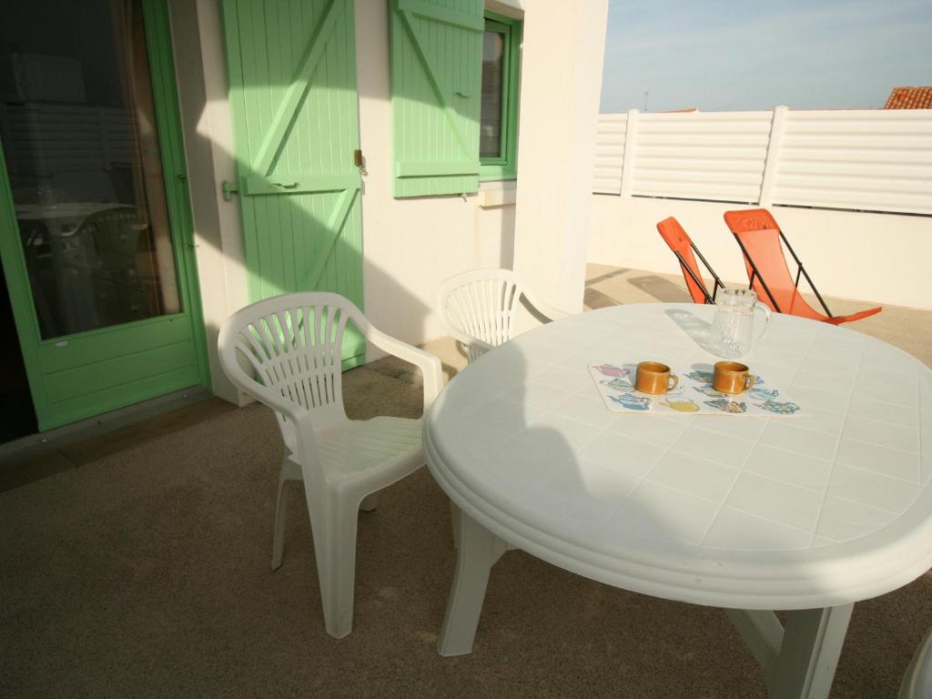 a white table with two chairs and a table with two cups at Maison La Tranche-sur-Mer, 2 pièces, 4 personnes - FR-1-22-182 in La Tranche-sur-Mer