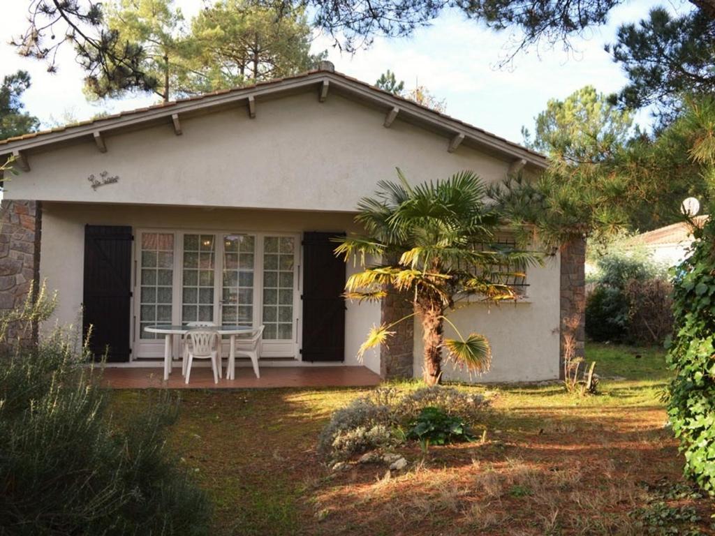 una pequeña casa blanca con una mesa en el patio en Maison La Tranche-sur-Mer, 4 pièces, 6 personnes - FR-1-22-235, en La Tranche-sur-Mer