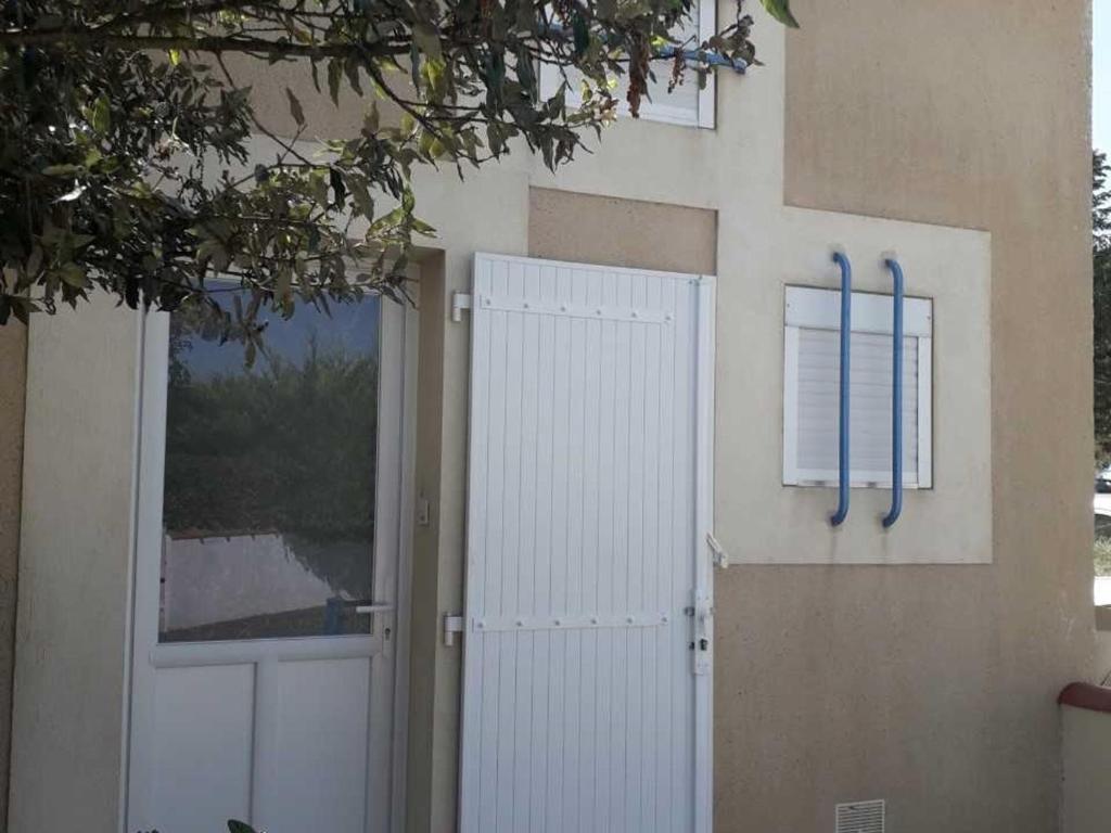 een gebouw met een witte deur en een klok erop bij Maison La Faute-sur-Mer, 3 pièces, 4 personnes - FR-1-476-58 in La Faute-sur-Mer