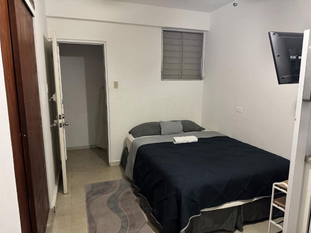 um quarto com uma cama com um edredão preto em 176 Calle Perez (4A2) em San Juan