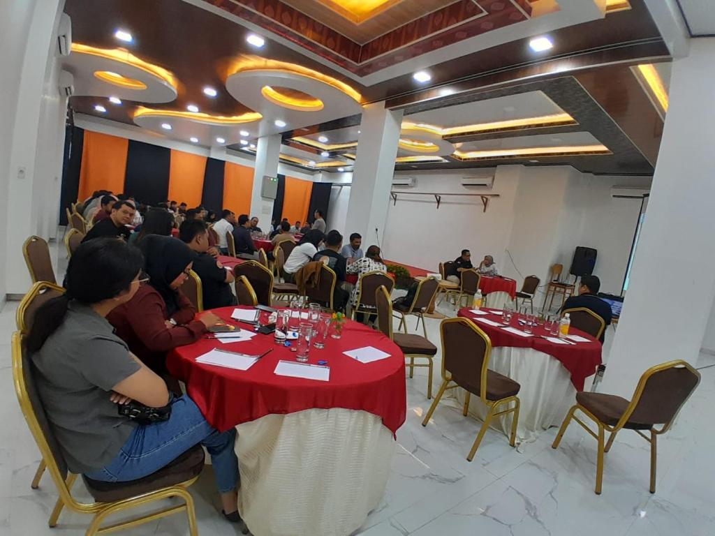 un gruppo di persone seduti ai tavoli in una stanza di TRAVELBIZ HOTEL a Medan