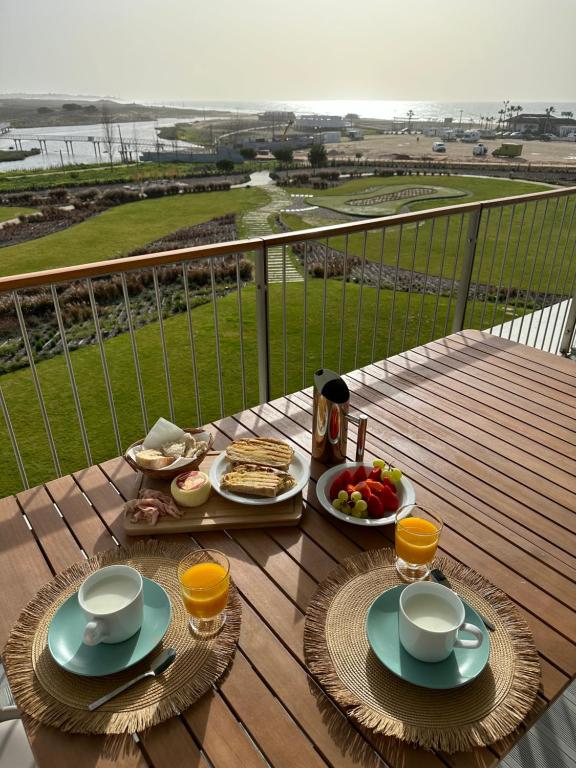 a table with food and drinks on top of a balcony at BaySun Apartment & SPA - Bayline in Armação de Pêra
