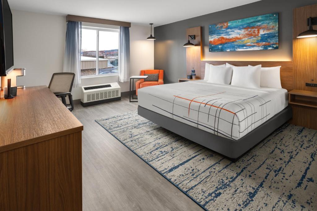 una camera d'albergo con letto e scrivania di La Quinta Inn & Suites by Wyndham Williston Burlington a Williston