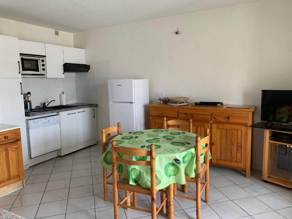 une cuisine avec une table, des chaises et un réfrigérateur dans l'établissement Charmant T2 à 2 pas de la plage avec terrasses, parking et local vélo – 5 pers, ménage inclus - FR-1-319-435, à Biscarrosse