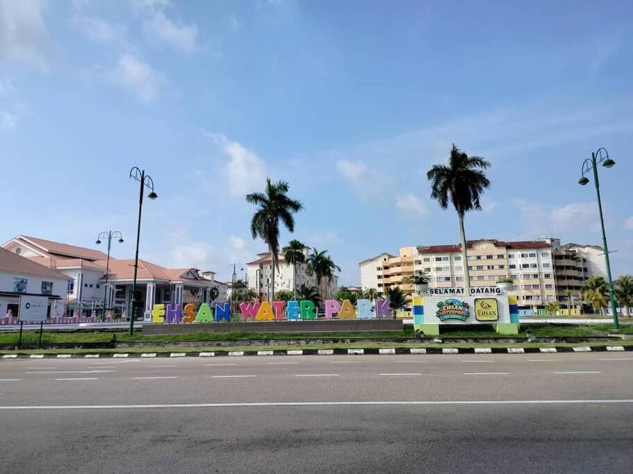 an empty street with palm trees and buildings in the background at Homestay Elina - Cheap and cosy in Port Dickson