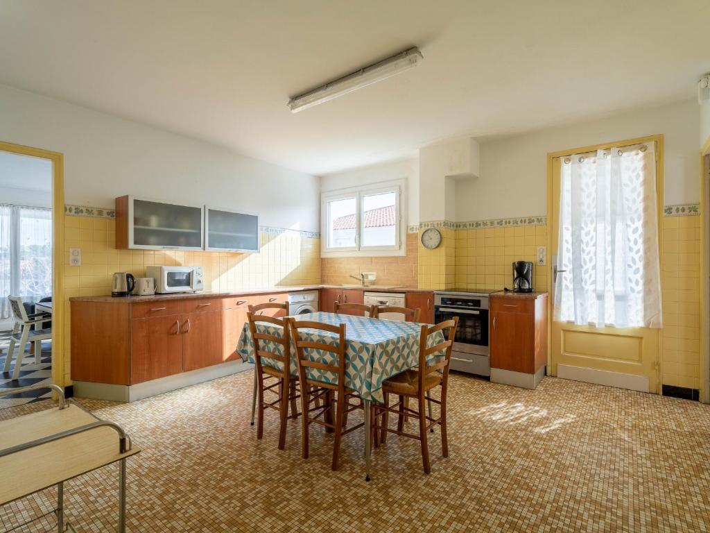 a kitchen with a table and chairs in a room at Maison Mimizan, 4 pièces, 6 personnes - FR-1-50-93 in Mimizan
