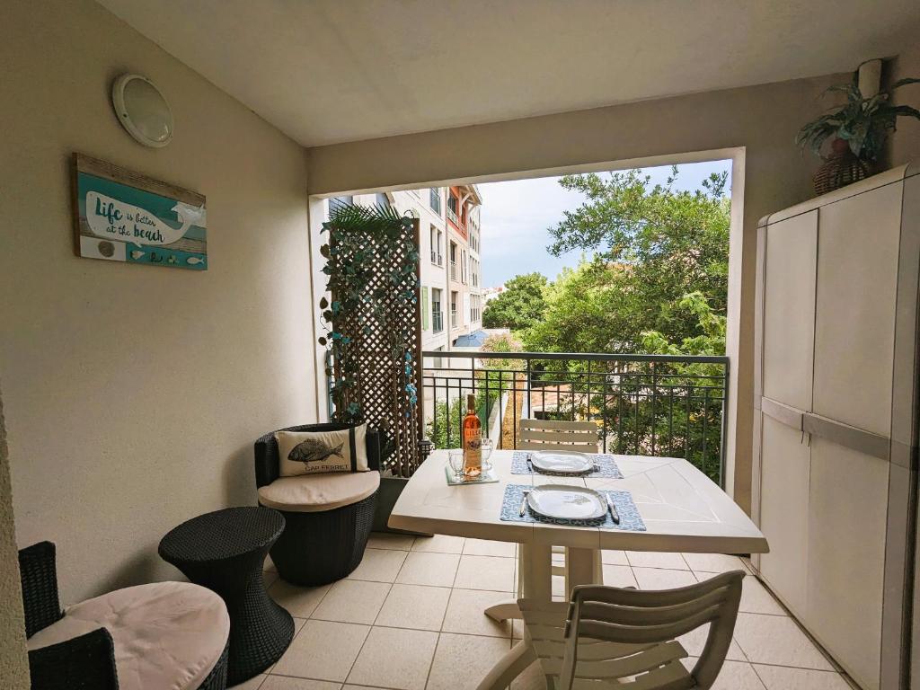 Cette chambre dispose d'un balcon avec une table et des chaises. dans l'établissement Arcachon centre, T2 de 47m², 200m plage, loggia, parking, idéal couple - FR-1-420-109, à Arcachon