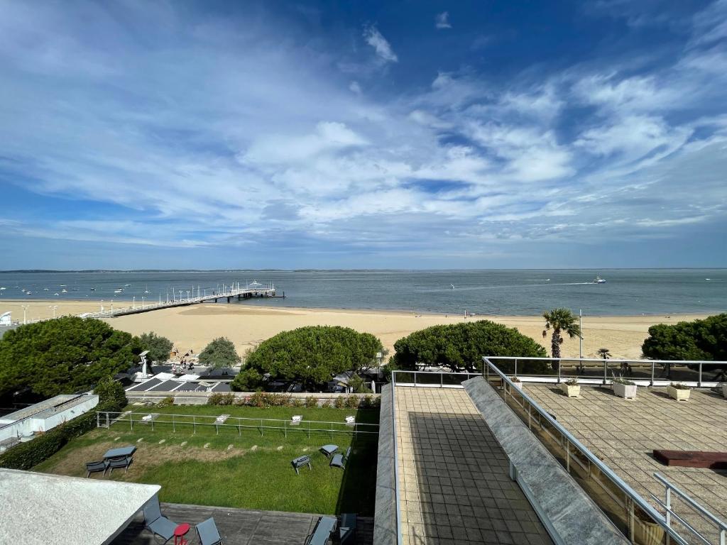 une vue sur une plage avec une jetée et l'océan dans l'établissement Appartement 4 chambres au dernier étage avec immense terrasse face au Bassin à Arcachon - FR-1-420-122, à Arcachon