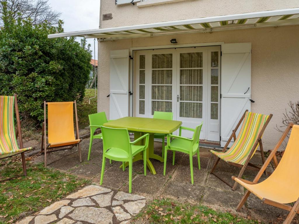 a table and chairs in front of a house at Appartement 4 pers, Pieds des Pistes Cyclables, Terrasse, BBQ, Proche Plages et Activités - FR-1-50-107 in Mimizan