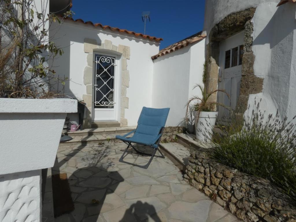 une chaise bleue assise sur une terrasse à côté d'un bâtiment dans l'établissement Maison spacieuse à Notre-Dame-de-Monts, proche plage, 3 chambres, terrasse et parking sécurisé - FR-1-540-179, à Notre-Dame-de-Monts