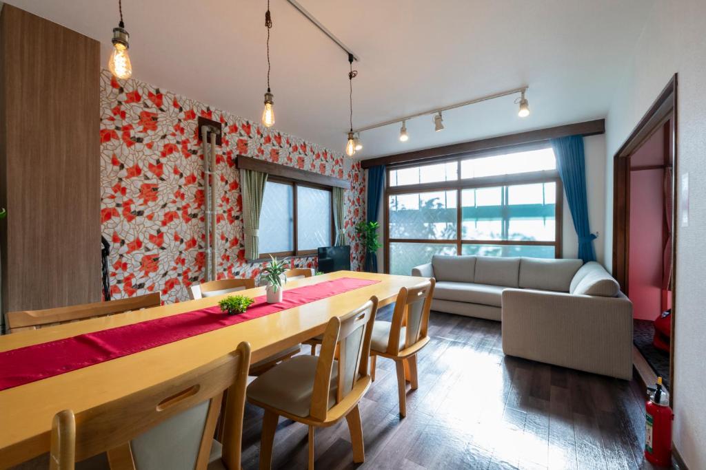 a dining room with a long table and chairs at HATSUNE in Otaru