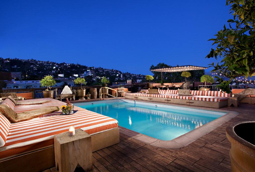 a swimming pool with a bed and a patio at Petit Ermitage in Los Angeles