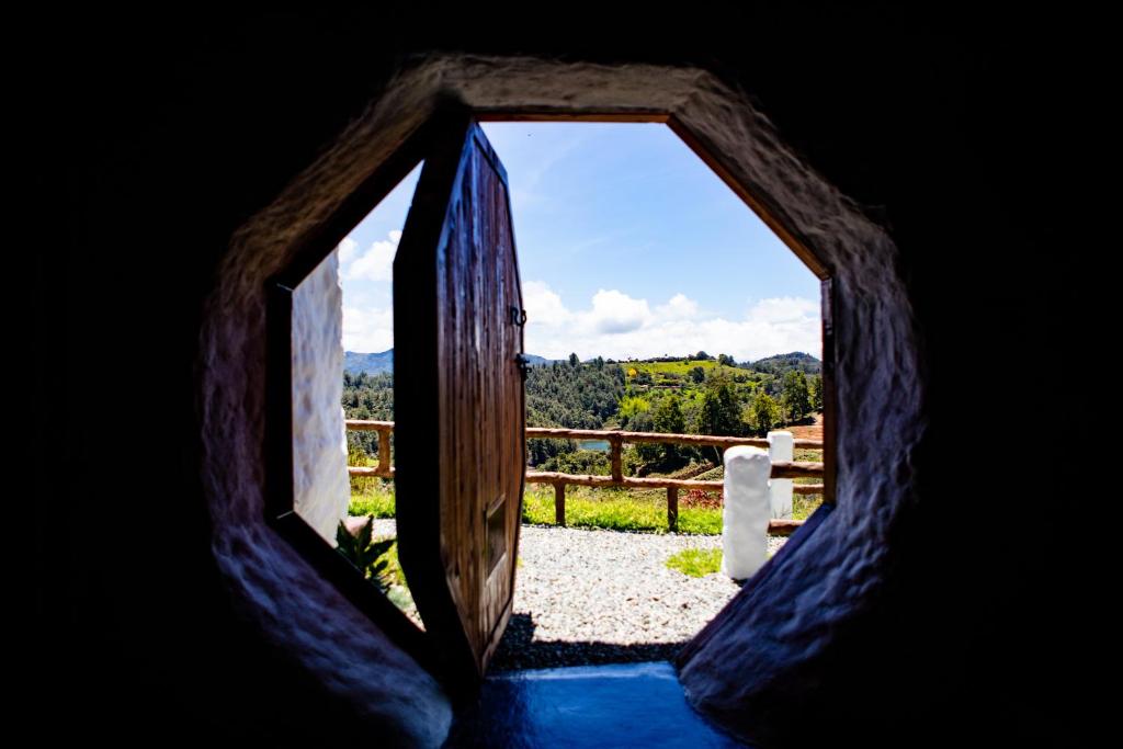 an opening in a cave with a view through a door at Hobbit Hotel Ecolodge- Guatapé in Guatapé