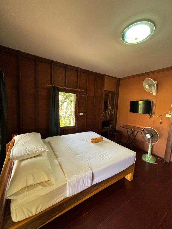 - une chambre avec un grand lit blanc et une fenêtre dans l'établissement Baan Ja Da, à Ban Nai Khlong