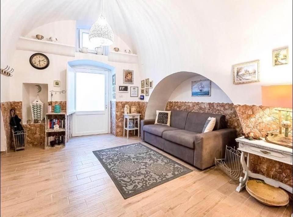 un soggiorno con un divano e un orologio a parete di Dimora luxury Santa Lucia Apartaments a Galatone
