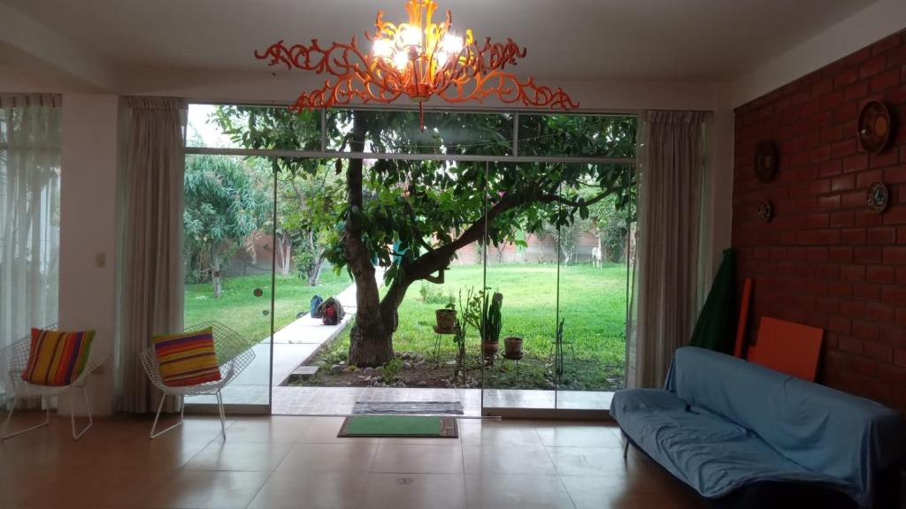 ein Wohnzimmer mit einem großen Fenster und einem Baum in der Unterkunft CASA DE CAMPO COCACHACRA LODGE in Cocachacra