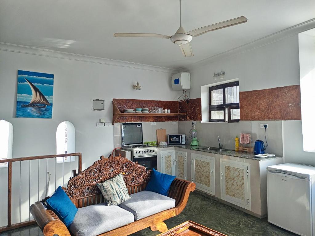 a living room with a couch and a kitchen at Seafarers Loft in Stone Town