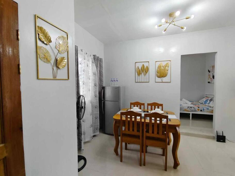 a dining room with a table and chairs and a refrigerator at JADEN Guesthouse in Davao City