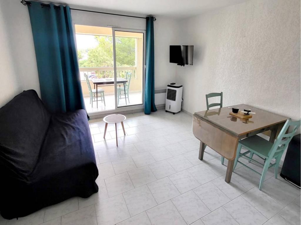 un salon avec un canapé et une table dans l'établissement Appartement T2 + Coin Nuit, Parking, Piscine/Tennis, à 200m Plages/Commerces - FR-1-316-323, à Six-Fours-les-Plages