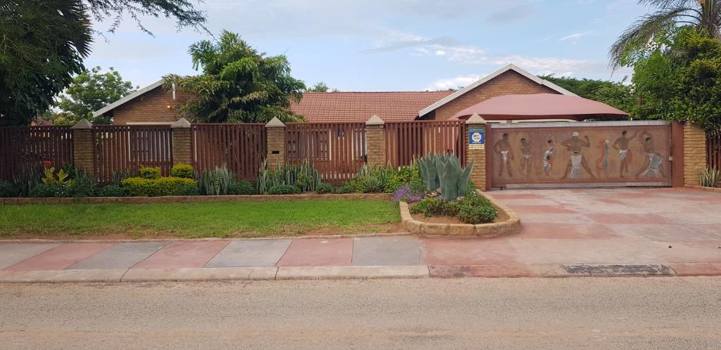 a house with a wooden fence and a driveway at Molata Rabs in Polokwane