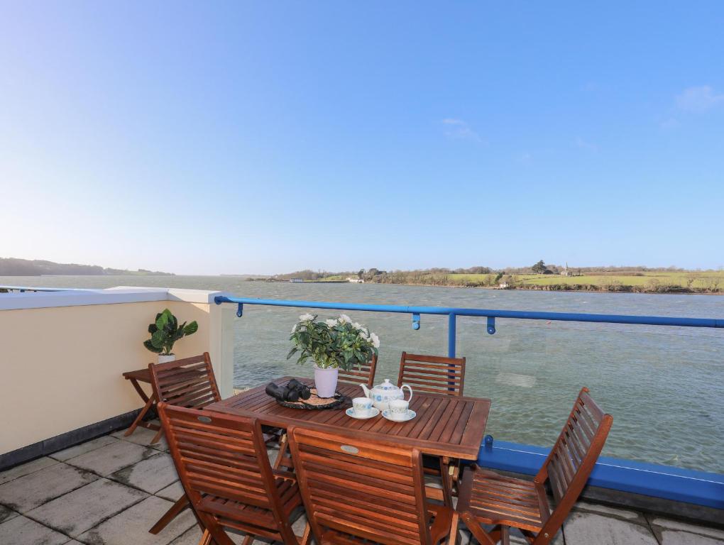 a table on a balcony with a view of the water at Dornberg in Y Felinheli