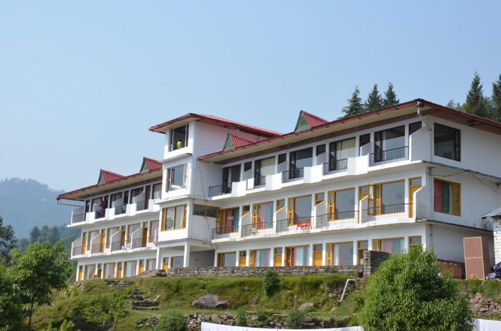 un grande edificio bianco in cima a una collina di Hotel Milam Inn a Munsyari