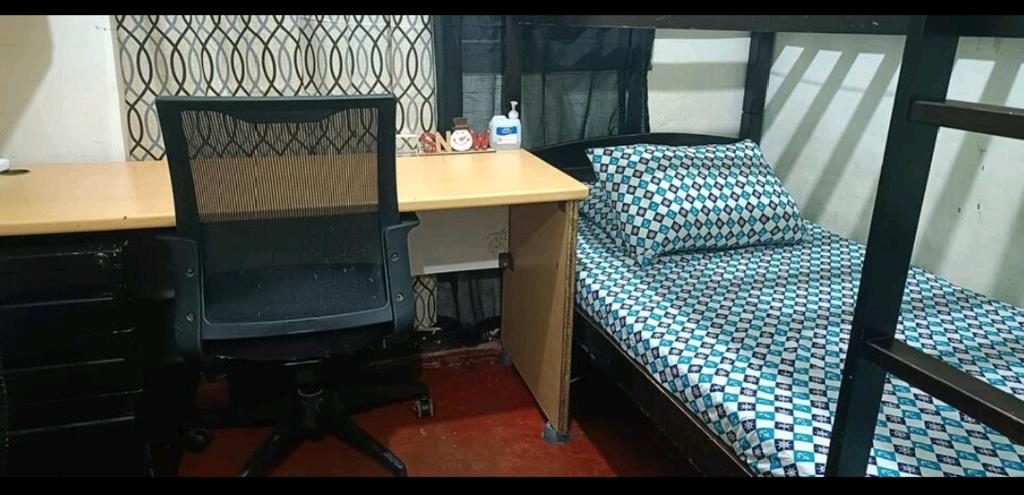- une chambre avec un bureau, un lit, un bureau et une chaise dans l'établissement Hannah HomeStay, à Manille