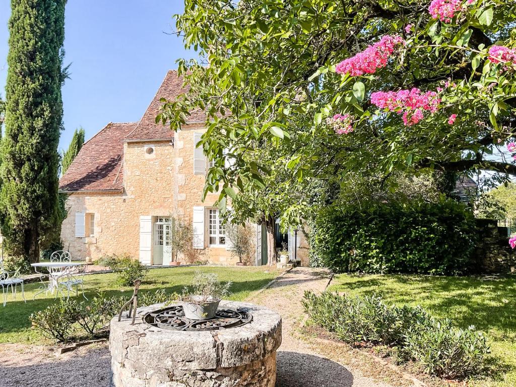 une maison avec un jardin et une fontaine en face de celle-ci dans l'établissement Domaine de pragelier, à Tourtoirac