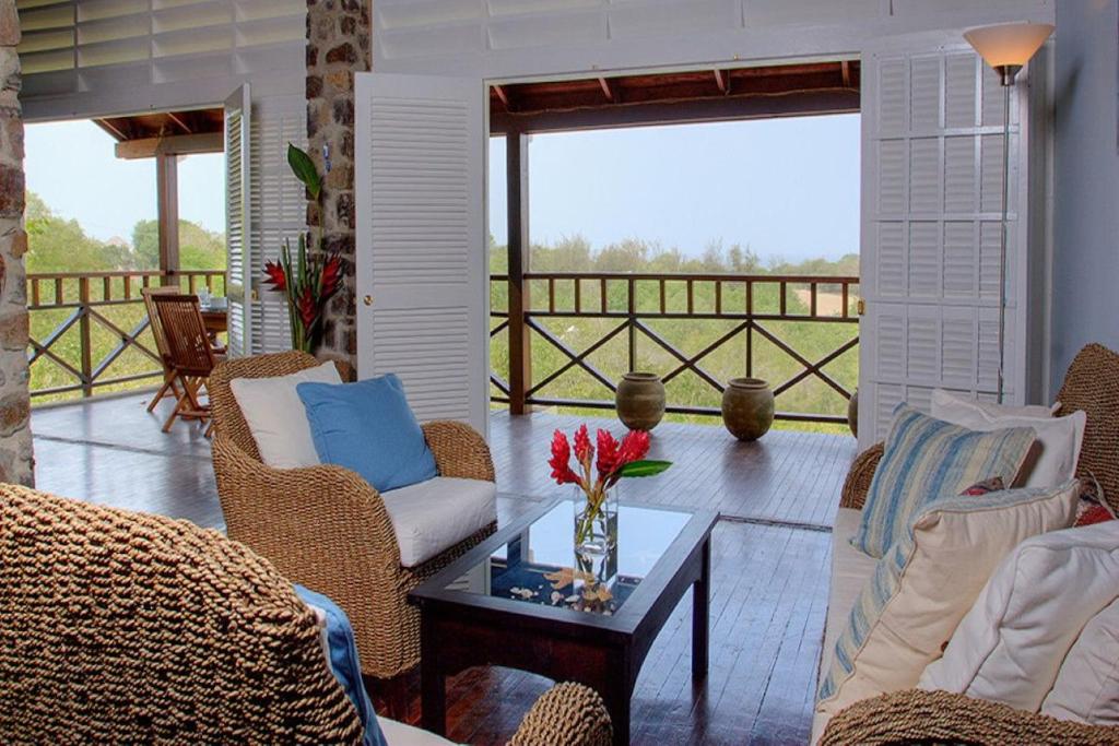 una sala de estar con sofás y una mesa con flores en Bright & Beautiful 2 Bedroom Villa, en Cap Estate