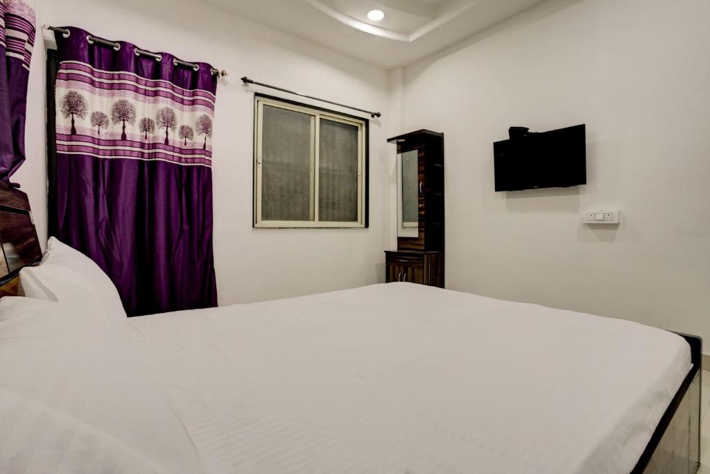 um quarto com uma cama branca e uma janela em OYO New Knaha In em Aurangabad