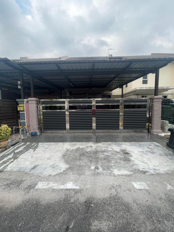 a large metal garage with awning in a parking lot at Amir Homestay in Yong Peng