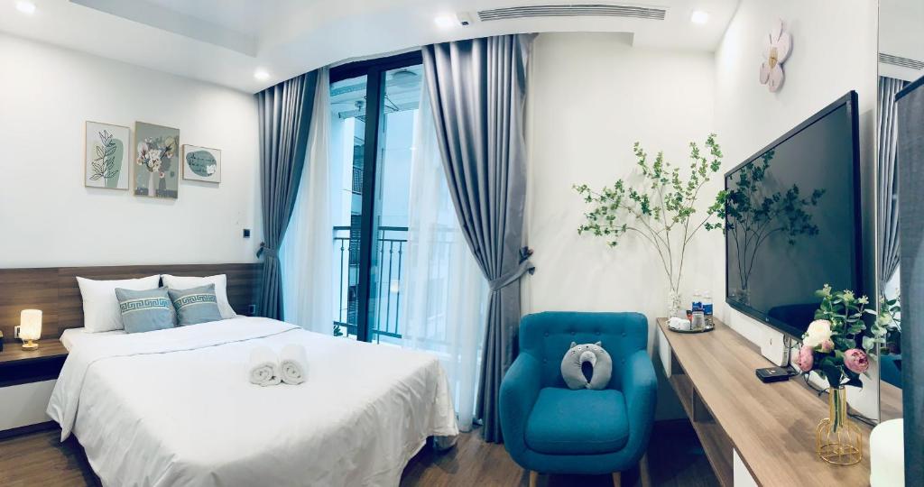 a bedroom with a bed and a blue chair at Studio cao cấp Vinhomes Greenbay Mễ trì giá rẻ nhất Hà Nội in Hanoi