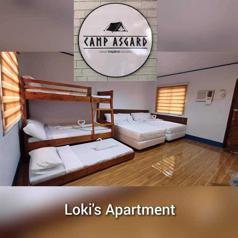 a room with three beds and a sign that reads lookkins apartment at LOKI'S APARTMENT in Catarman