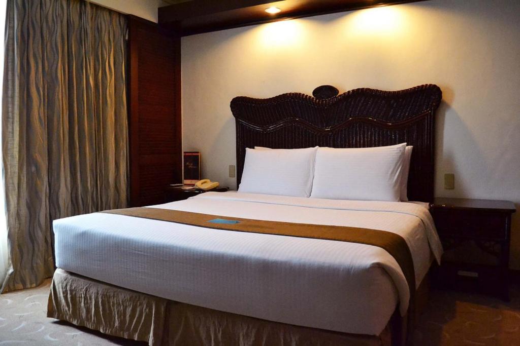 a bedroom with a large bed in a hotel room at Waterfront Airport Hotel and Casino in Mactan