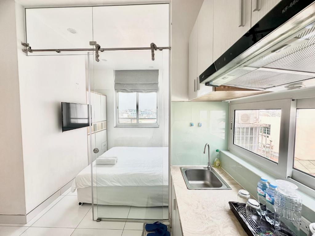 a kitchen with a sink and a bed in a room at Aloha House Apartment in Ho Chi Minh City