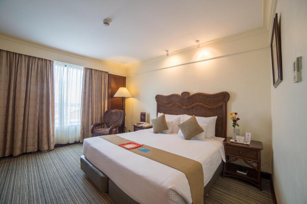 a hotel room with a large bed and a window at Waterfront Airport Hotel and Casino in Mactan