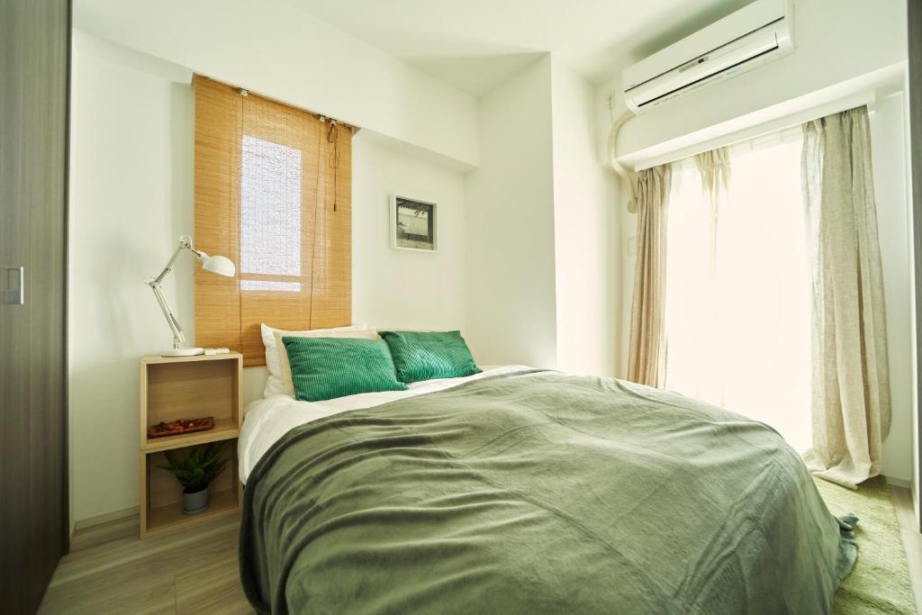Schlafzimmer mit einem Bett und einem Fenster in der Unterkunft 琢居．日暮里布里斯托酒店 Nippori Bristol Hotel in Tokio