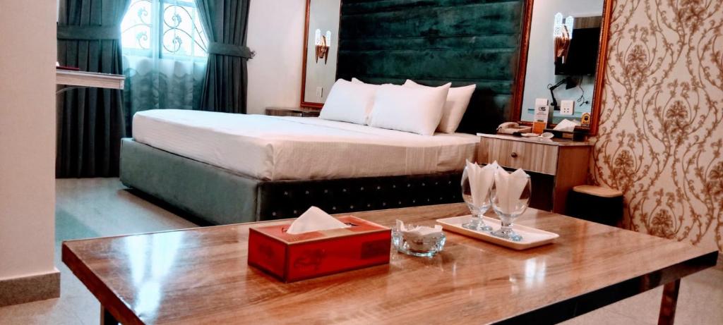 a hotel room with a bed and a table with a box at Grand Swiss Hotel&Apartment Lahore in Lahore
