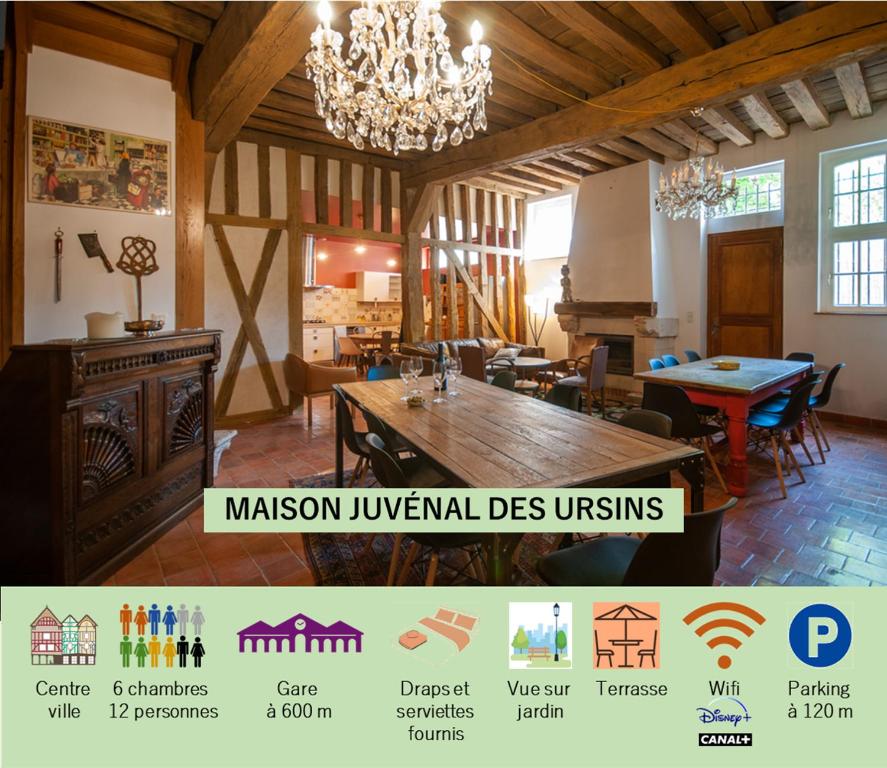 Habitación grande con mesa de madera y lámpara de araña. en Maison Juvénal des Ursins, en Troyes